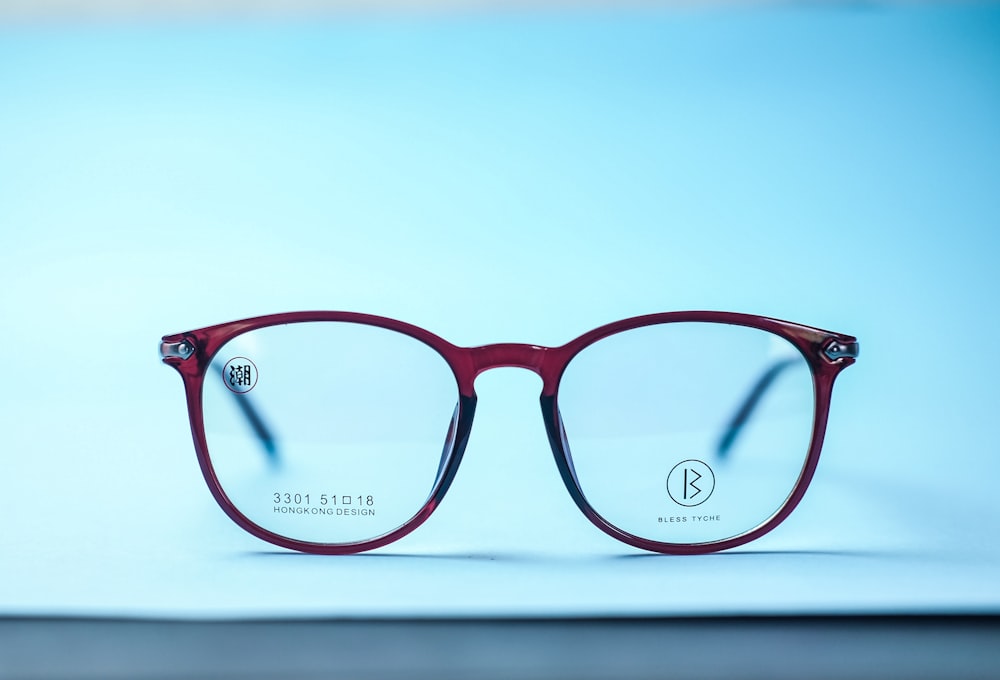 red framed eyeglasses on white table