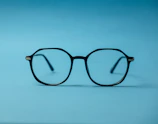 black framed eyeglasses on white surface
