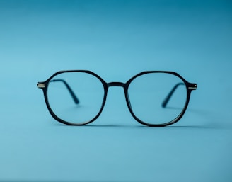 black framed eyeglasses on white surface