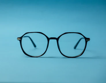 black framed eyeglasses on white surface