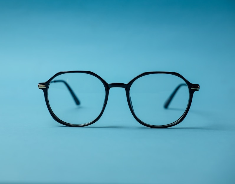 black framed eyeglasses on white surface