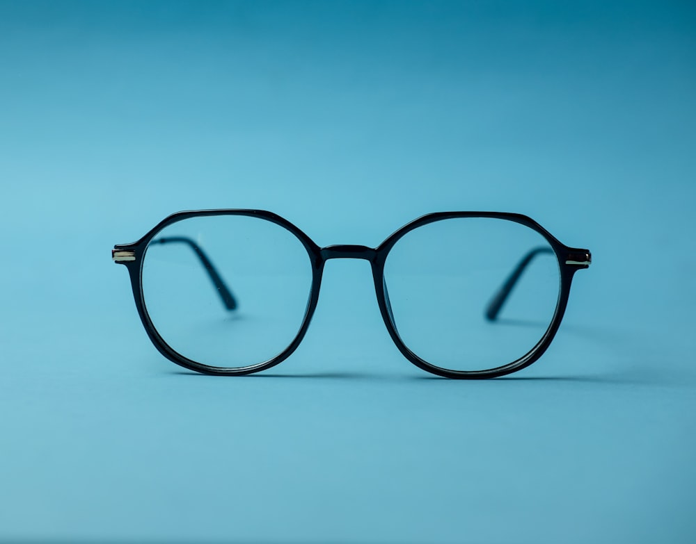 black framed eyeglasses on white surface