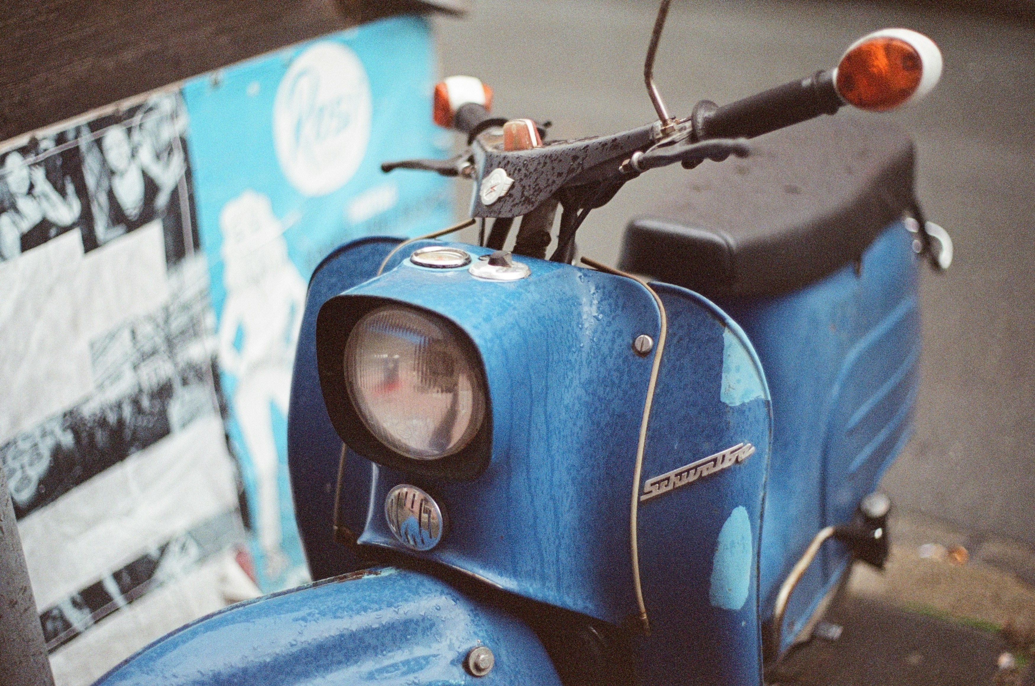 blue and black motorcycle near white and blue wall