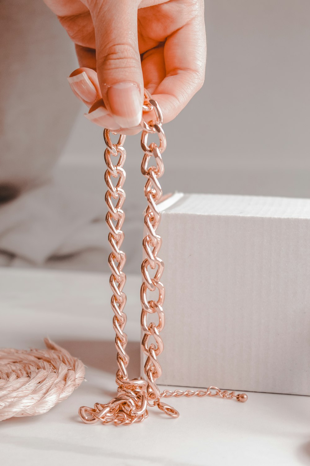 person holding gold chain link