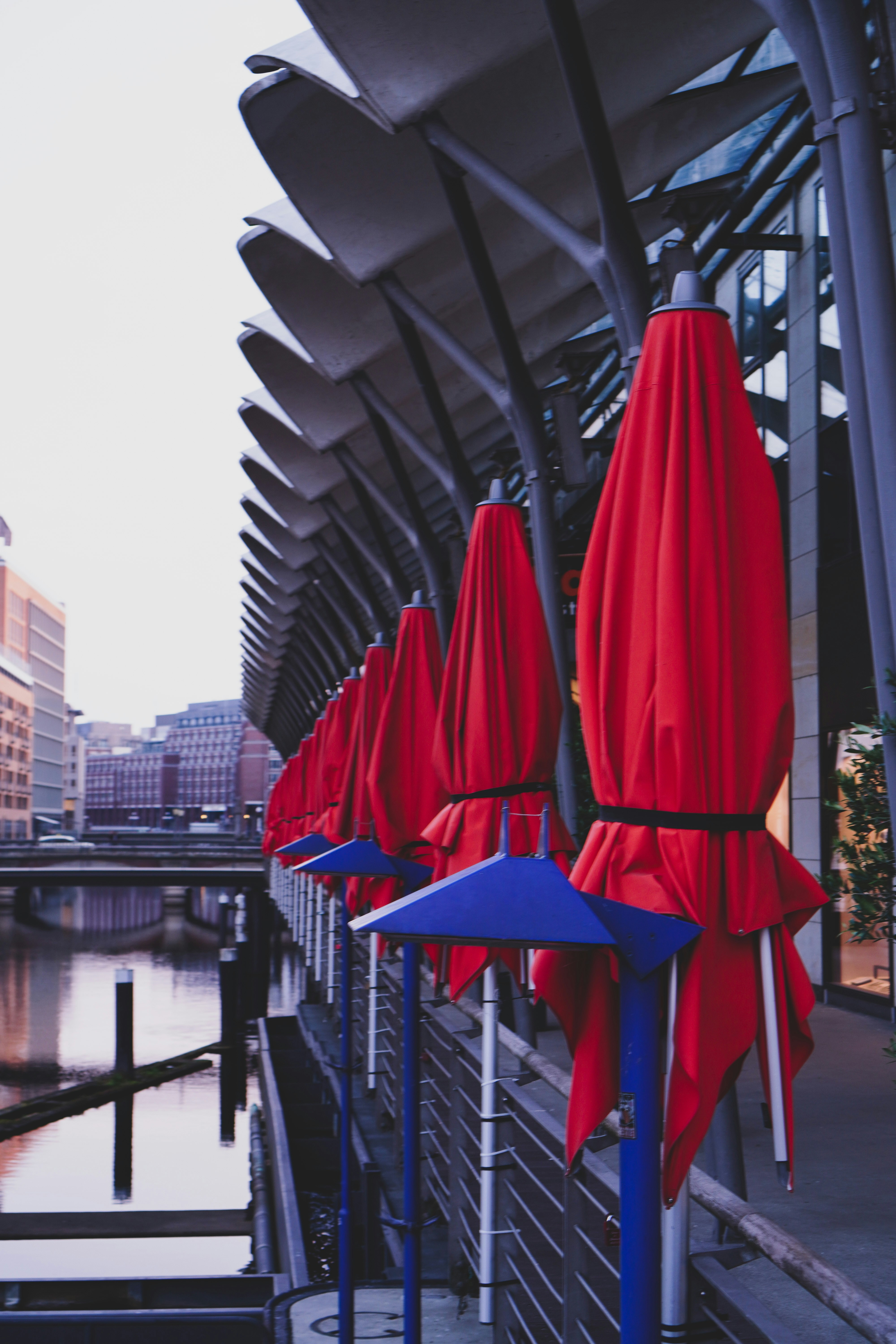 red patio umbrella near body of water during daytime
