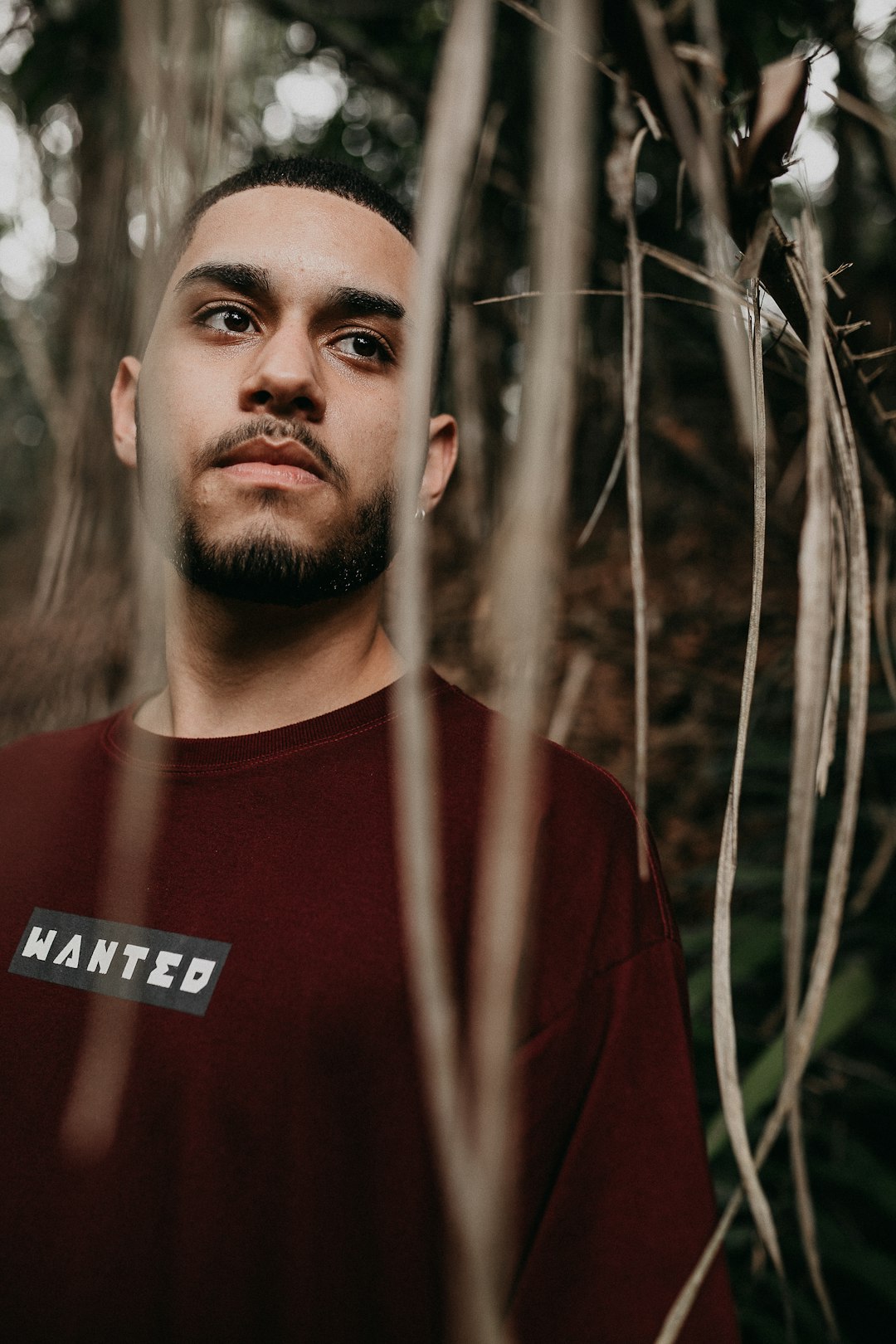 man in red crew neck shirt standing near green plants during daytime