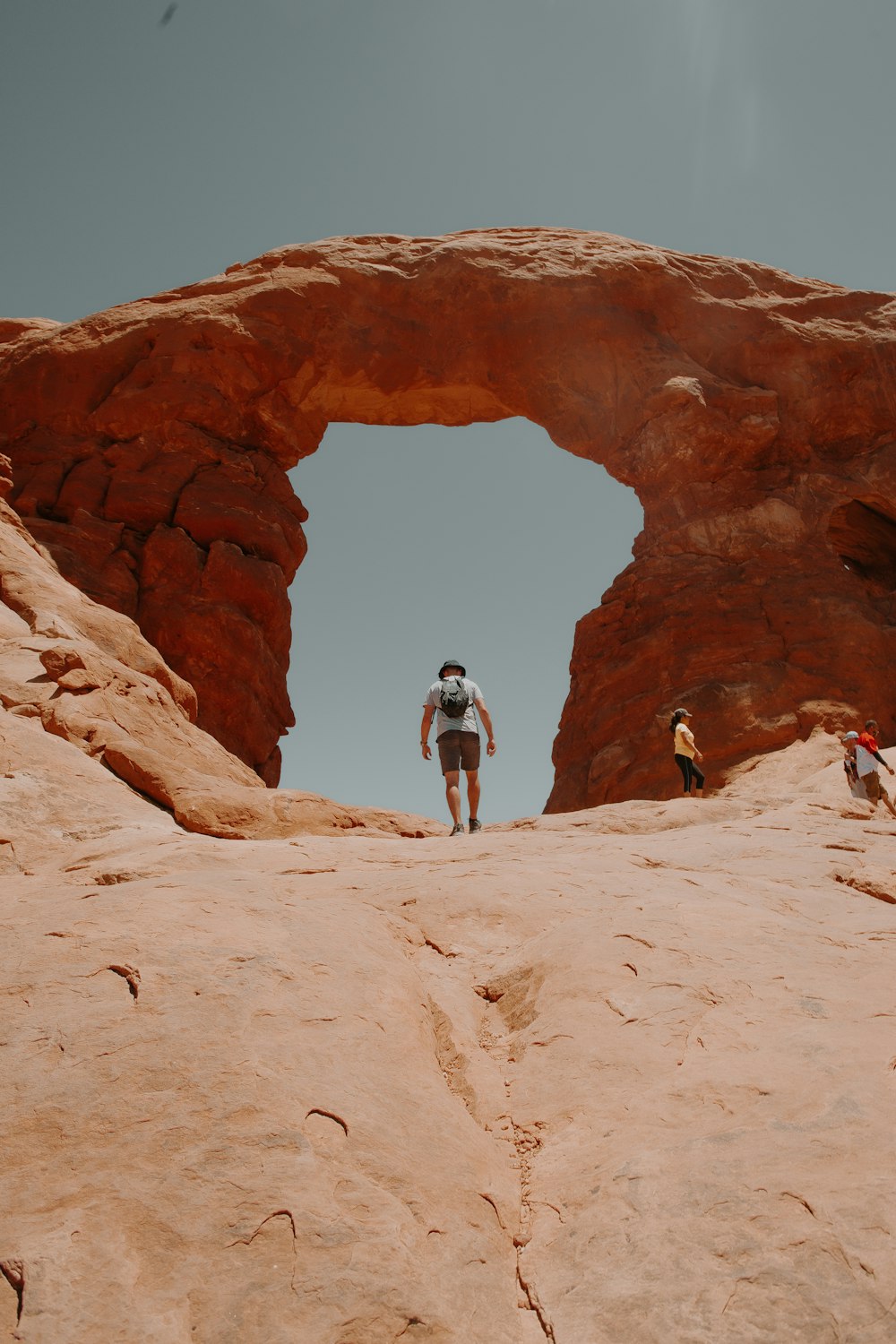 man in black jacket and black pants standing on brown rock formation during daytime