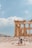 A group of travelers exploring ancient ruins under a clear blue sky.