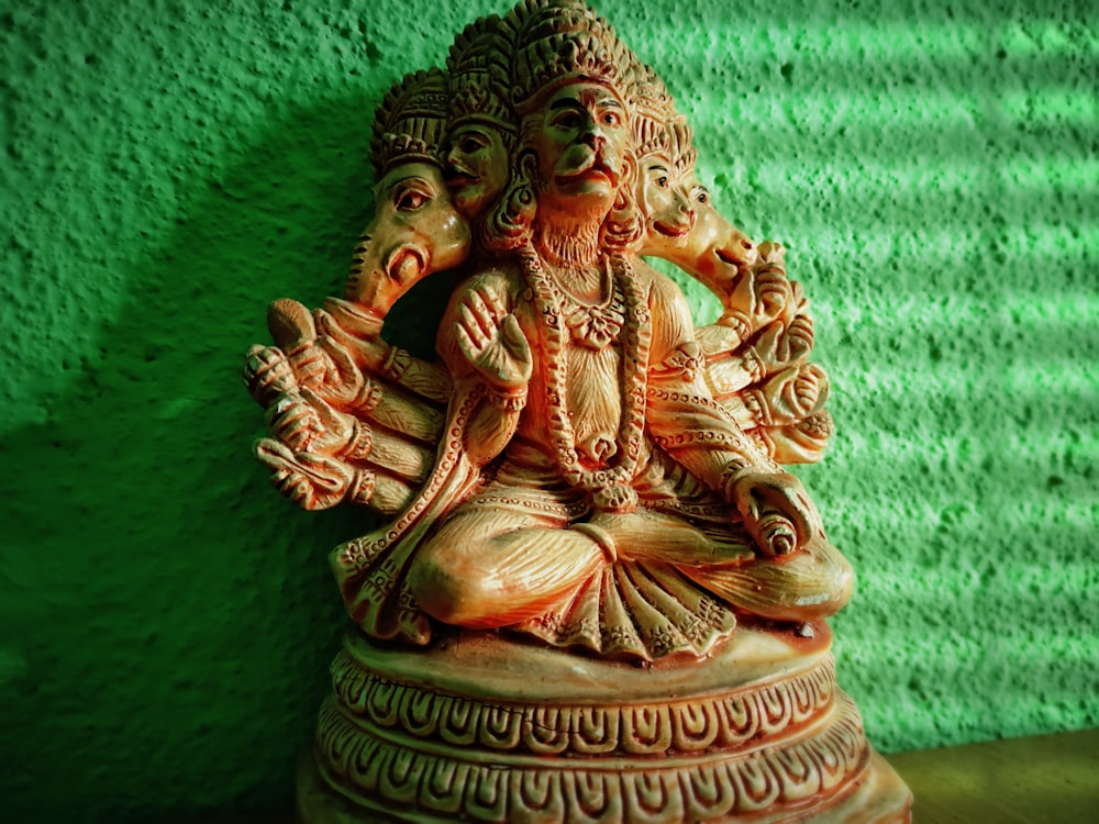 estatueta da divindade hindu do ouro no têxtil verde