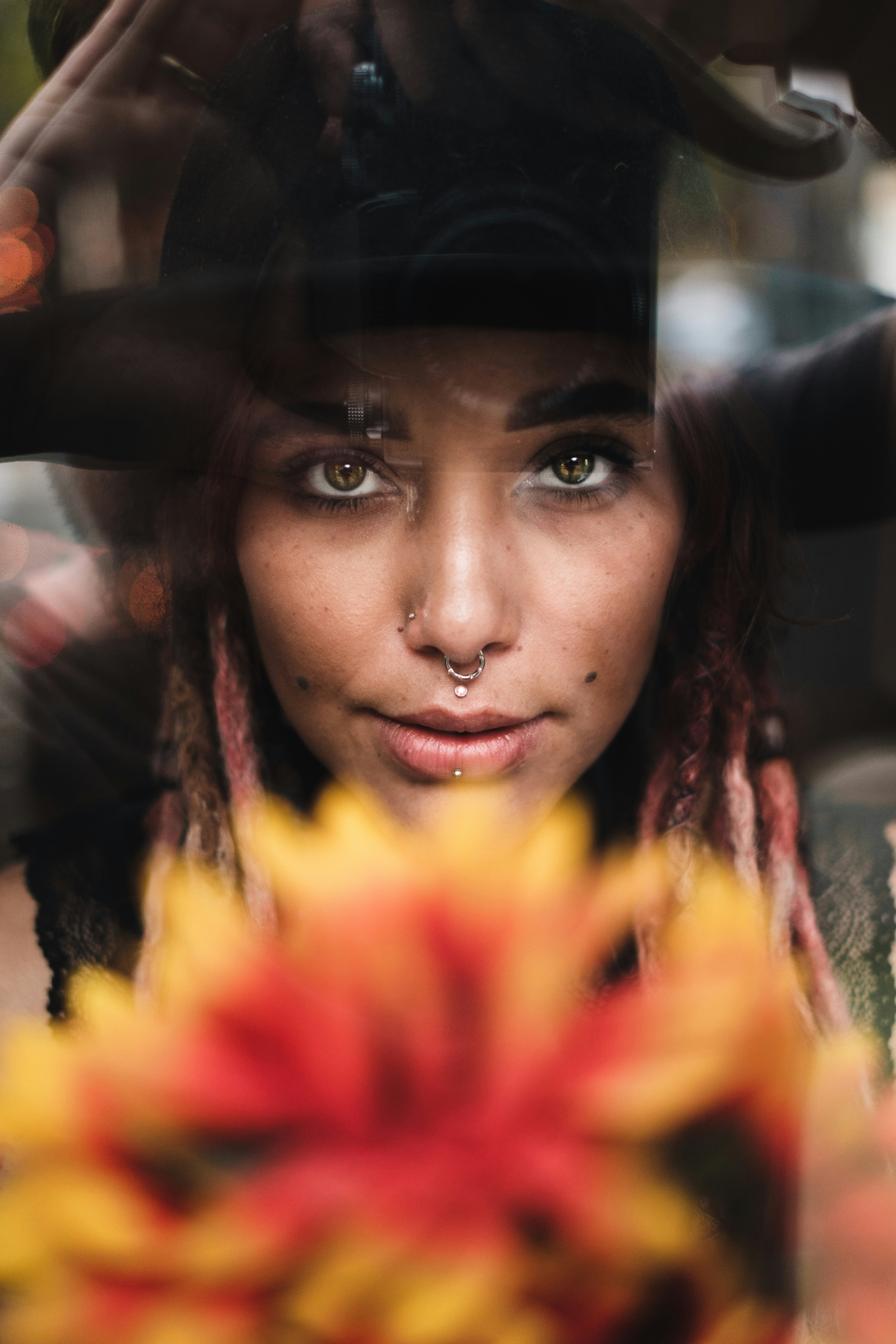 woman in black hat and yellow and red floral shirt