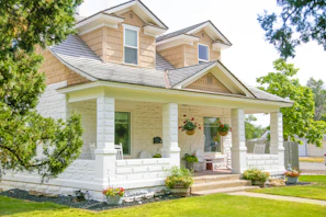 Front view of a charming two-story house with a porch.