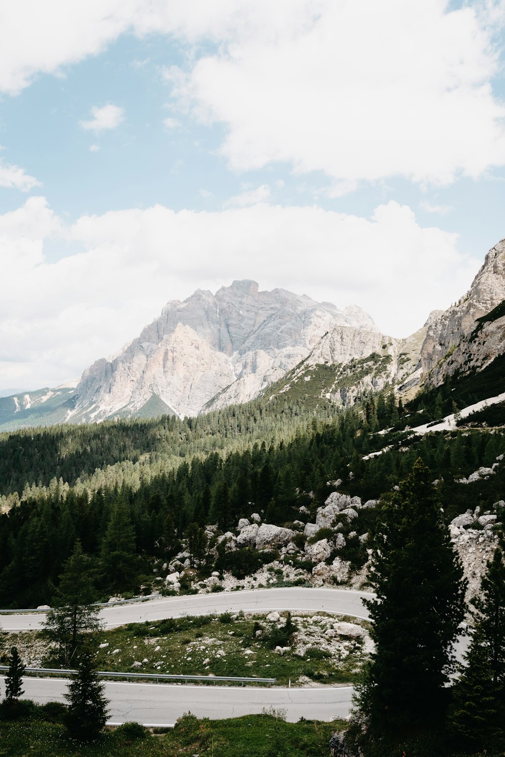 green pine trees near mountain under white clouds during daytime