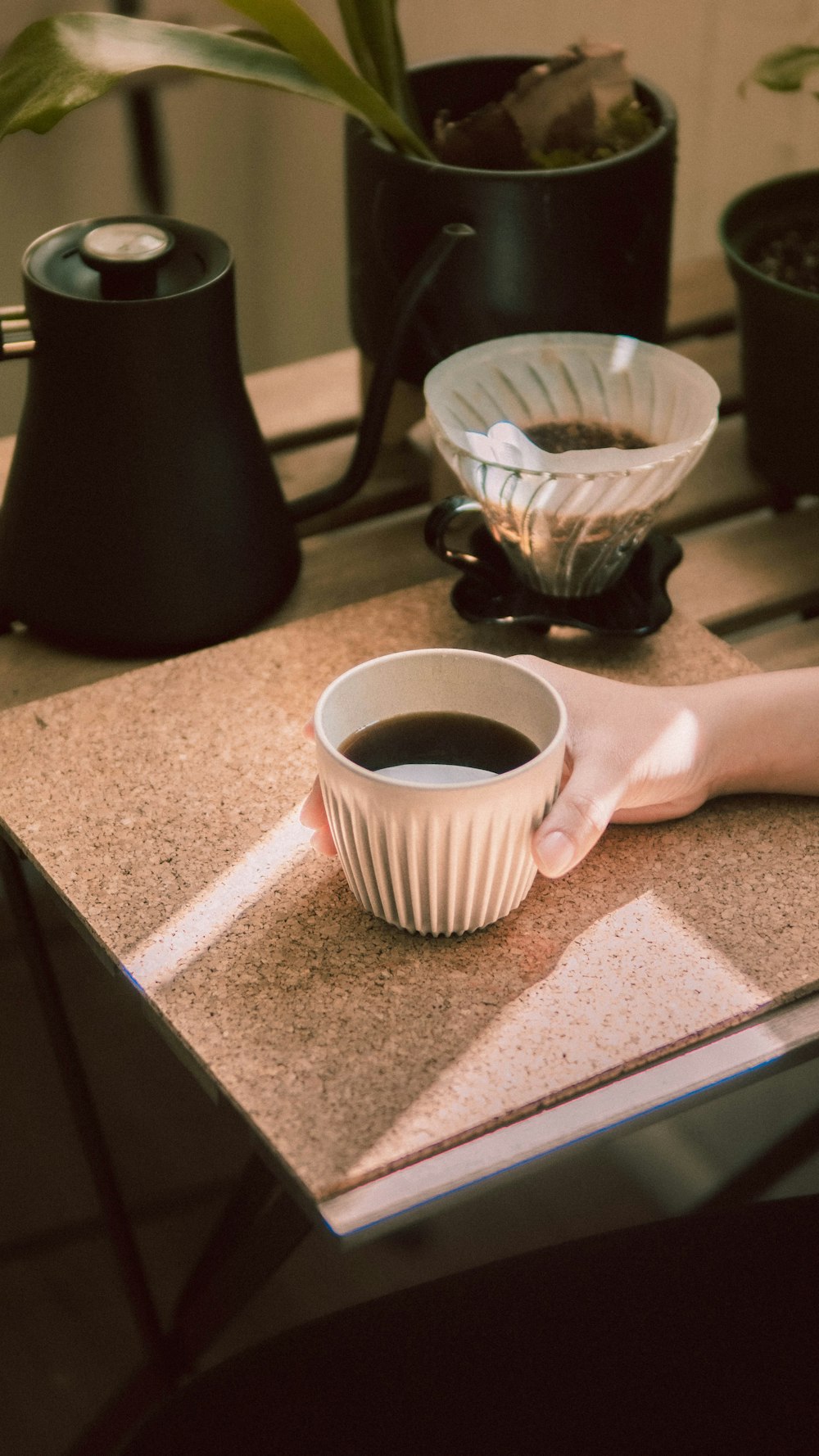 Person mit weißem Keramikbecher mit Kaffee