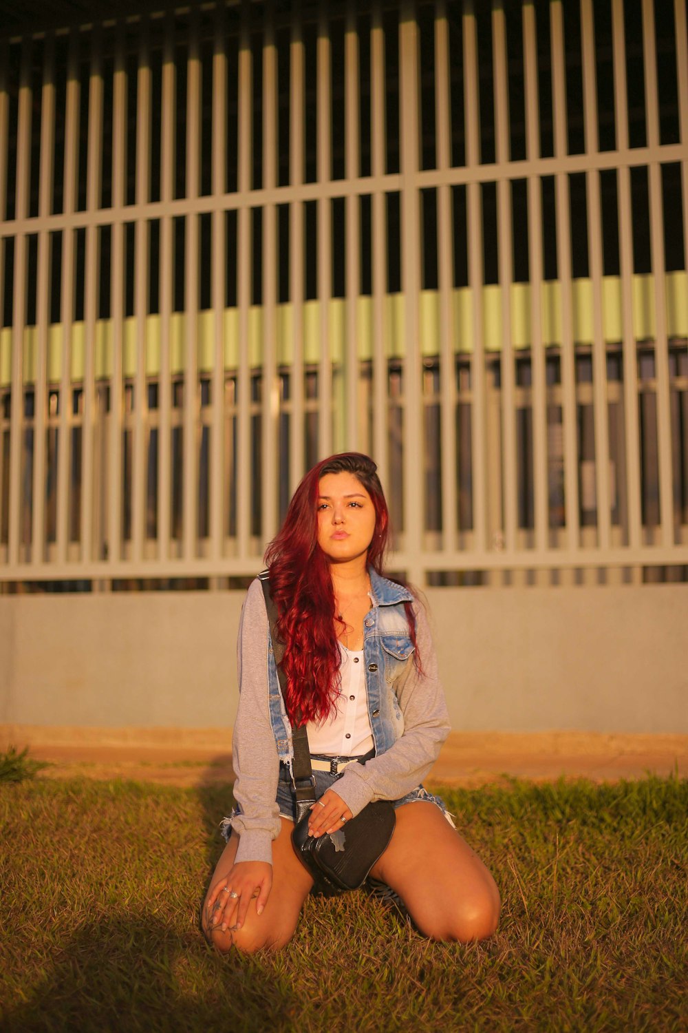 woman in blue denim button up jacket standing on green grass field during daytime