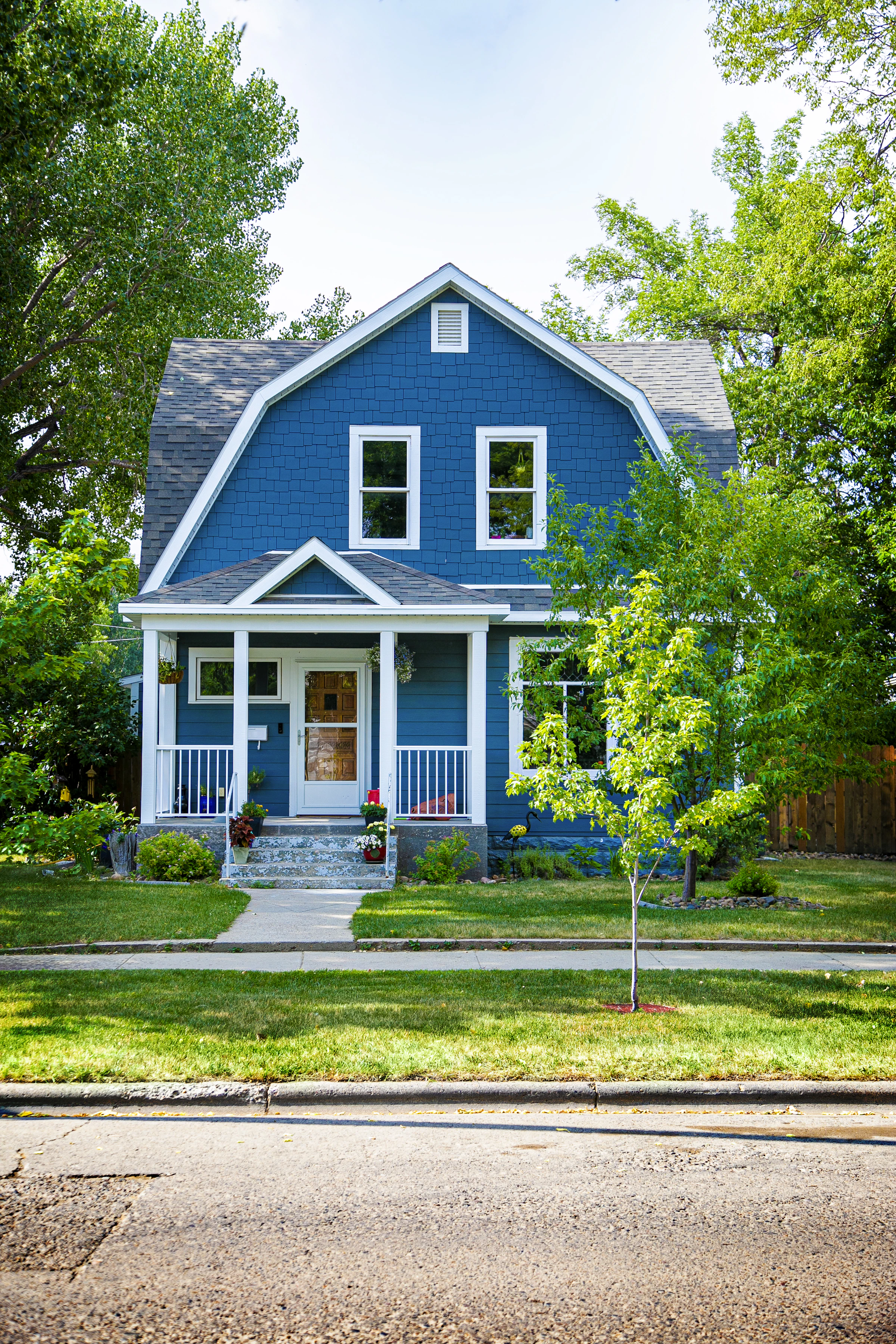 Blue home with white trim and a welcoming front porch