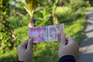person holding 10000 indonesian rupiah