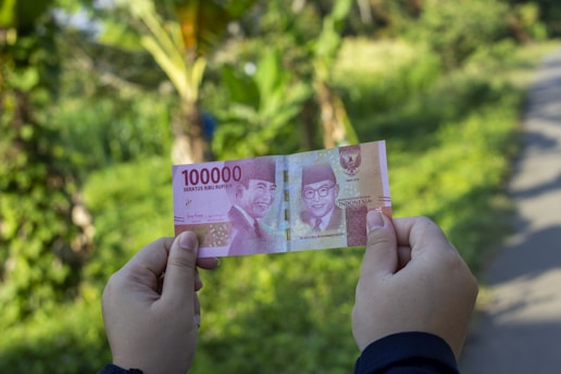 person holding 10000 indonesian rupiah