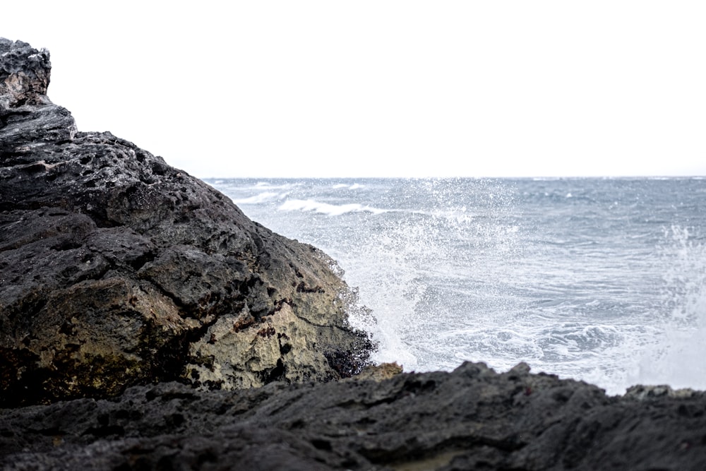 brown rock formation beside sea