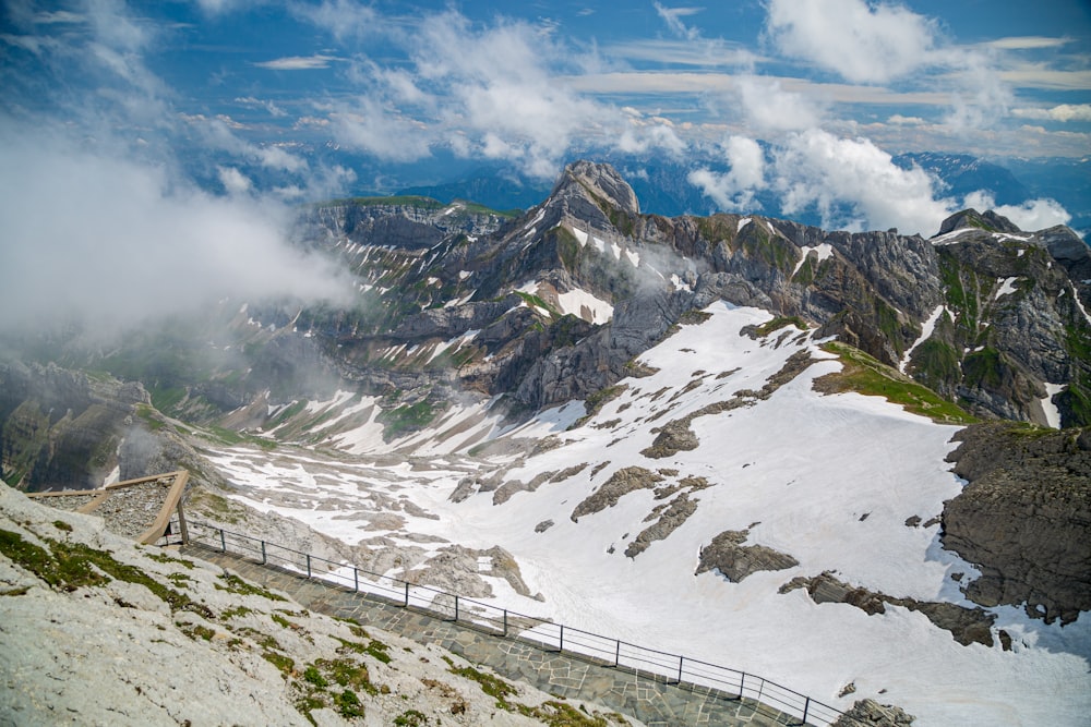 white and black mountains under white clouds and blue sky during daytime