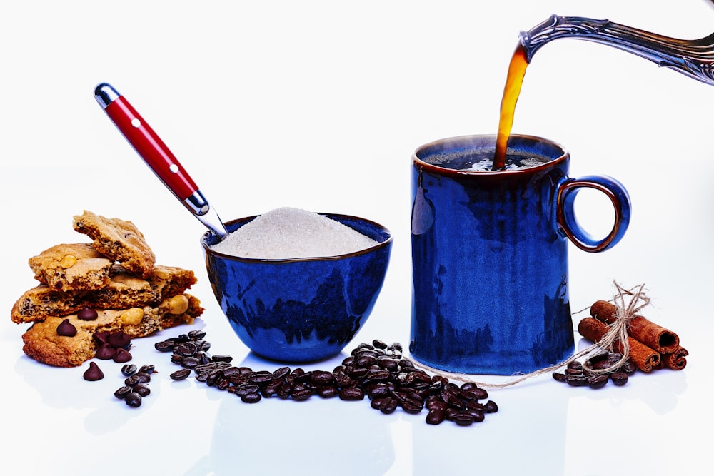 blue ceramic mug with red and yellow handled scissors