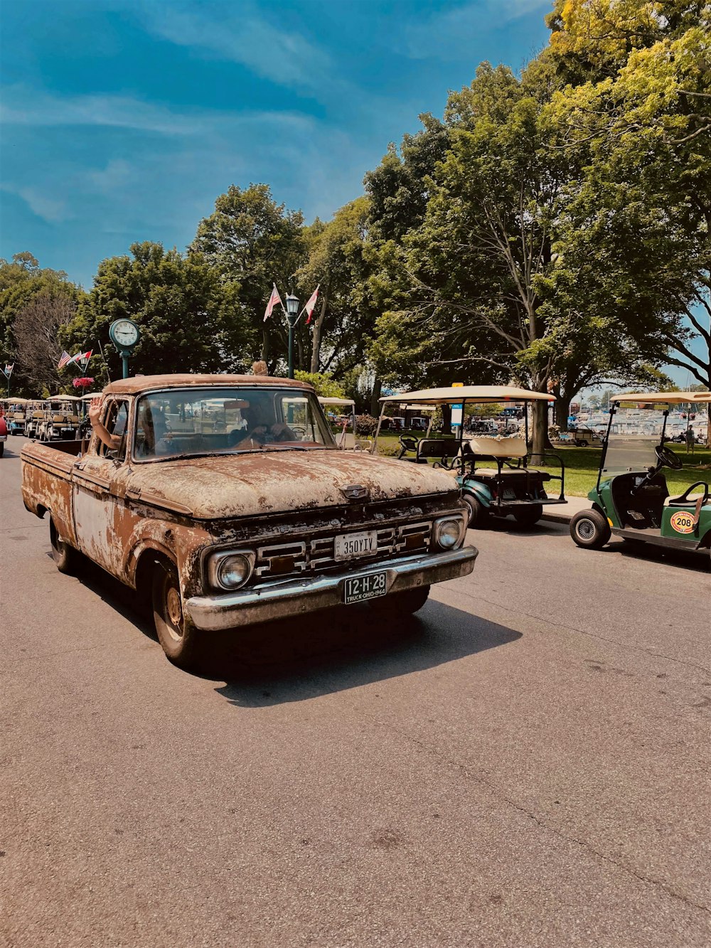 brown and white vintage car parked on gray asphalt road during daytime