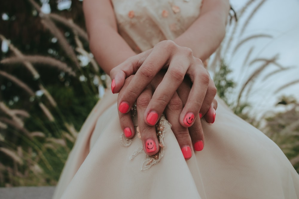woman in white dress with red manicure
