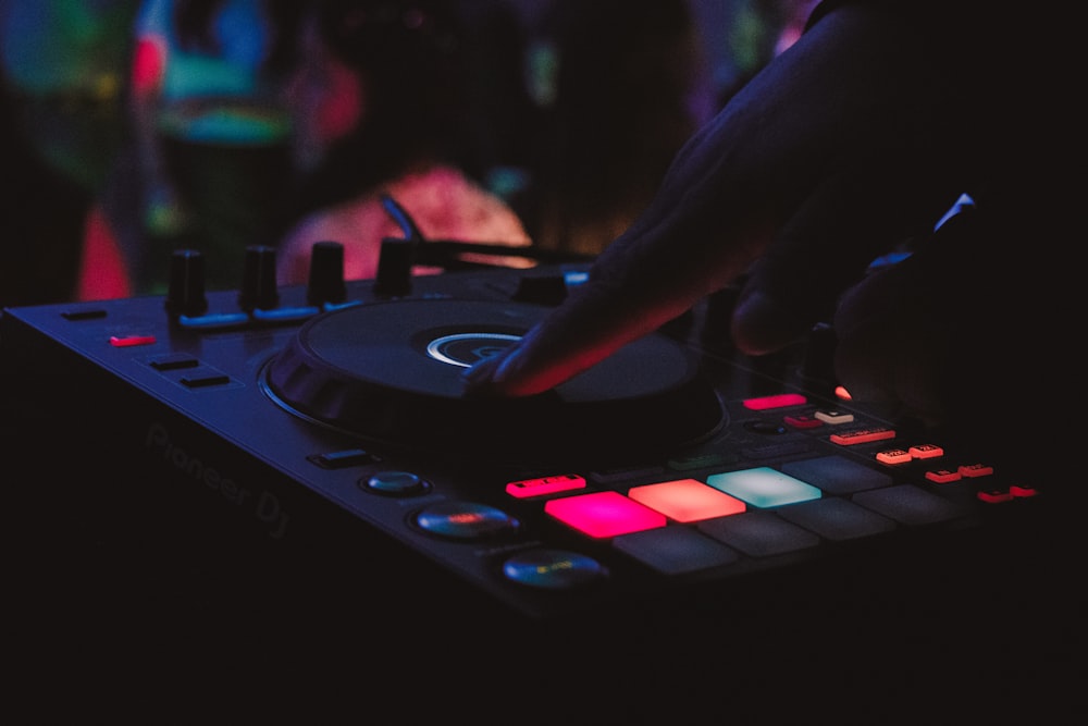 person playing dj controller in a dark room