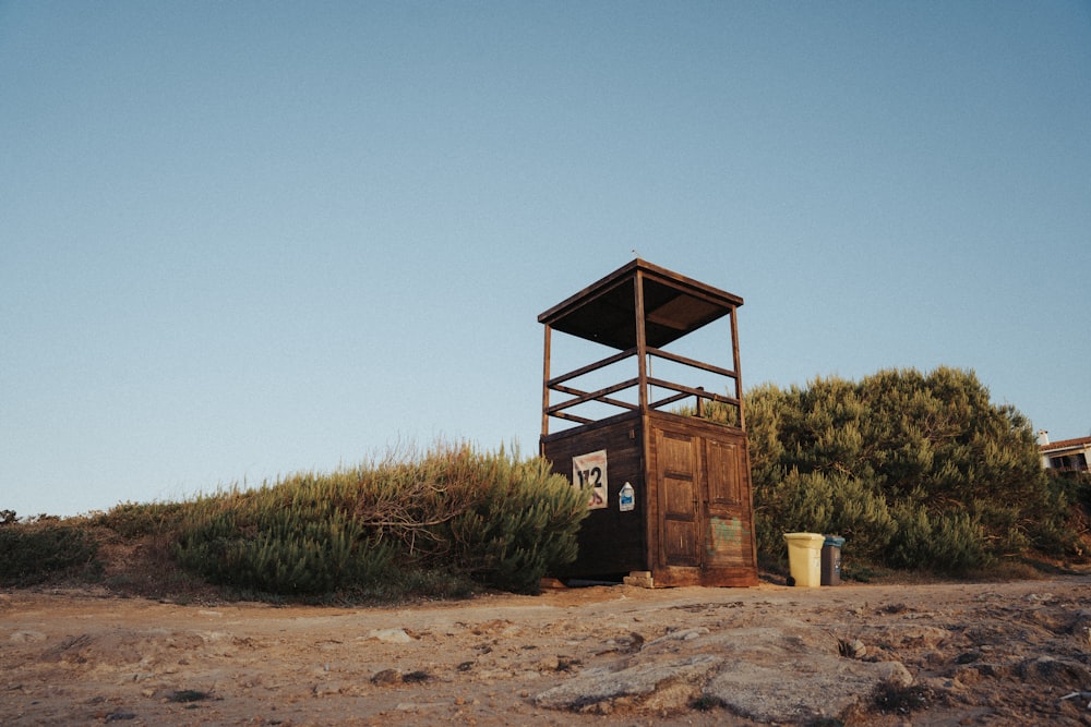 brown wooden lifeguard tower on brown sand during daytime