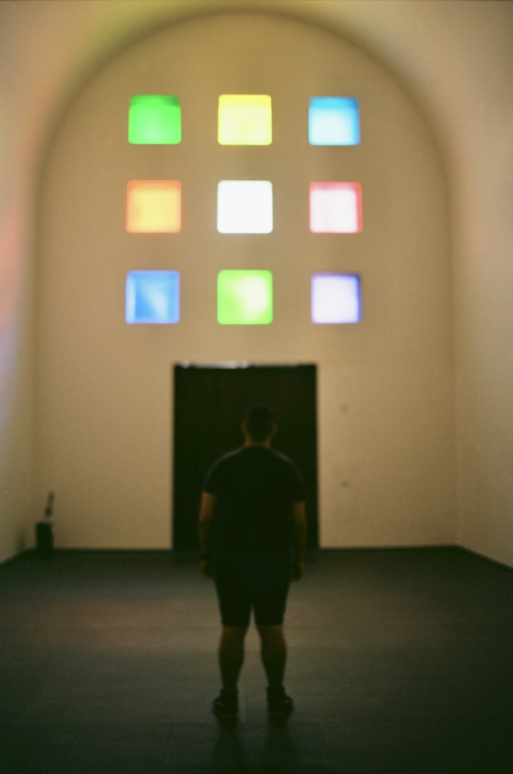 man in black jacket standing near white wall