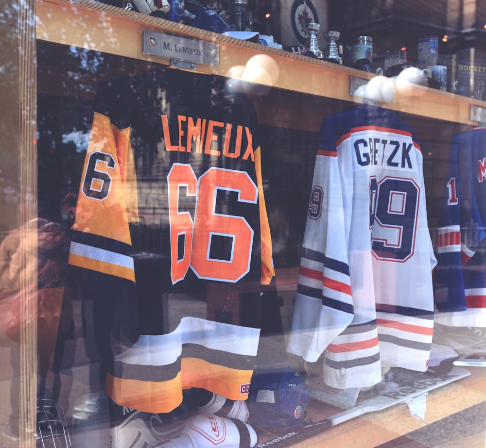 hockey jerseys are displayed in a window of a store