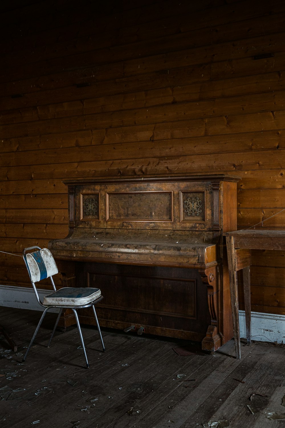 brown wooden upright piano beside brown wooden wall