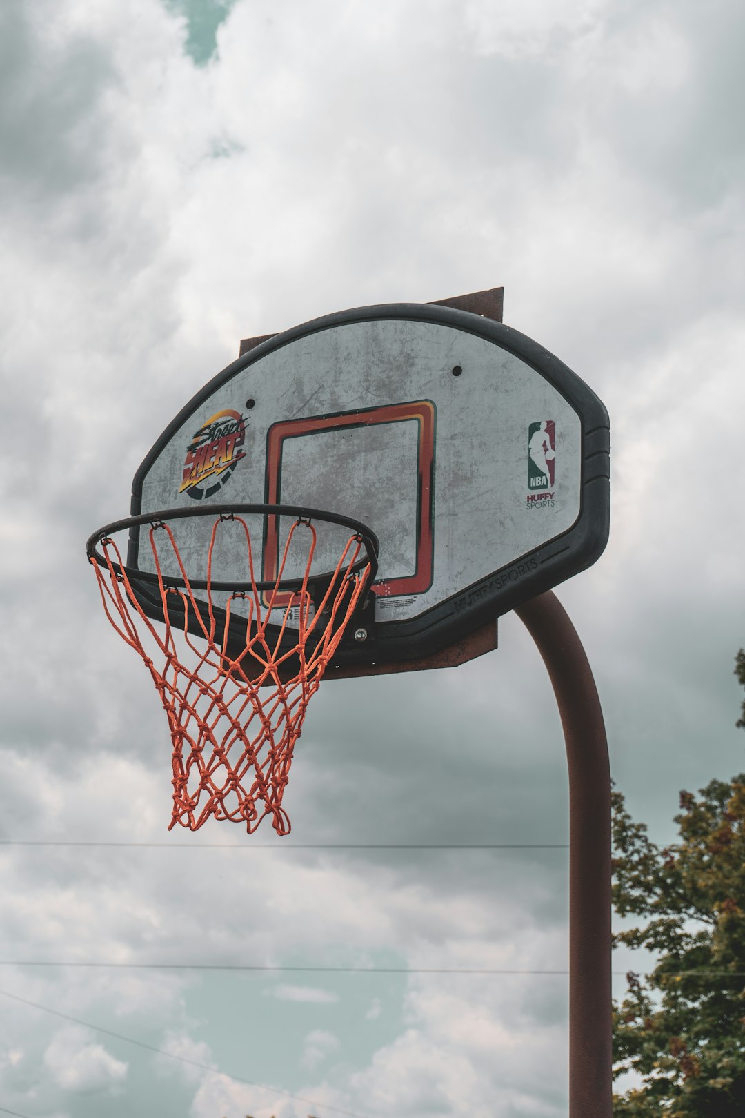 gray and red basketball hoop under cloudy sky during daytime