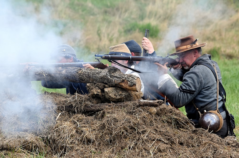 man in black jacket holding black rifle