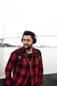 man in red and black plaid button up shirt standing near body of water during daytime