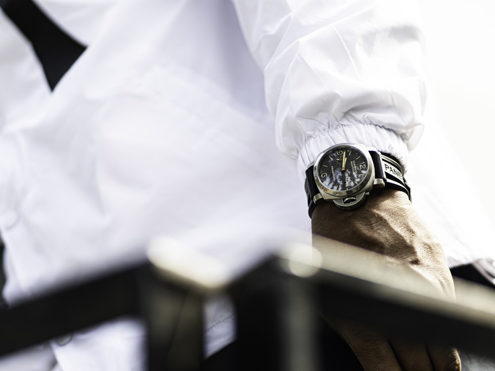 person wearing gold and black chronograph watch