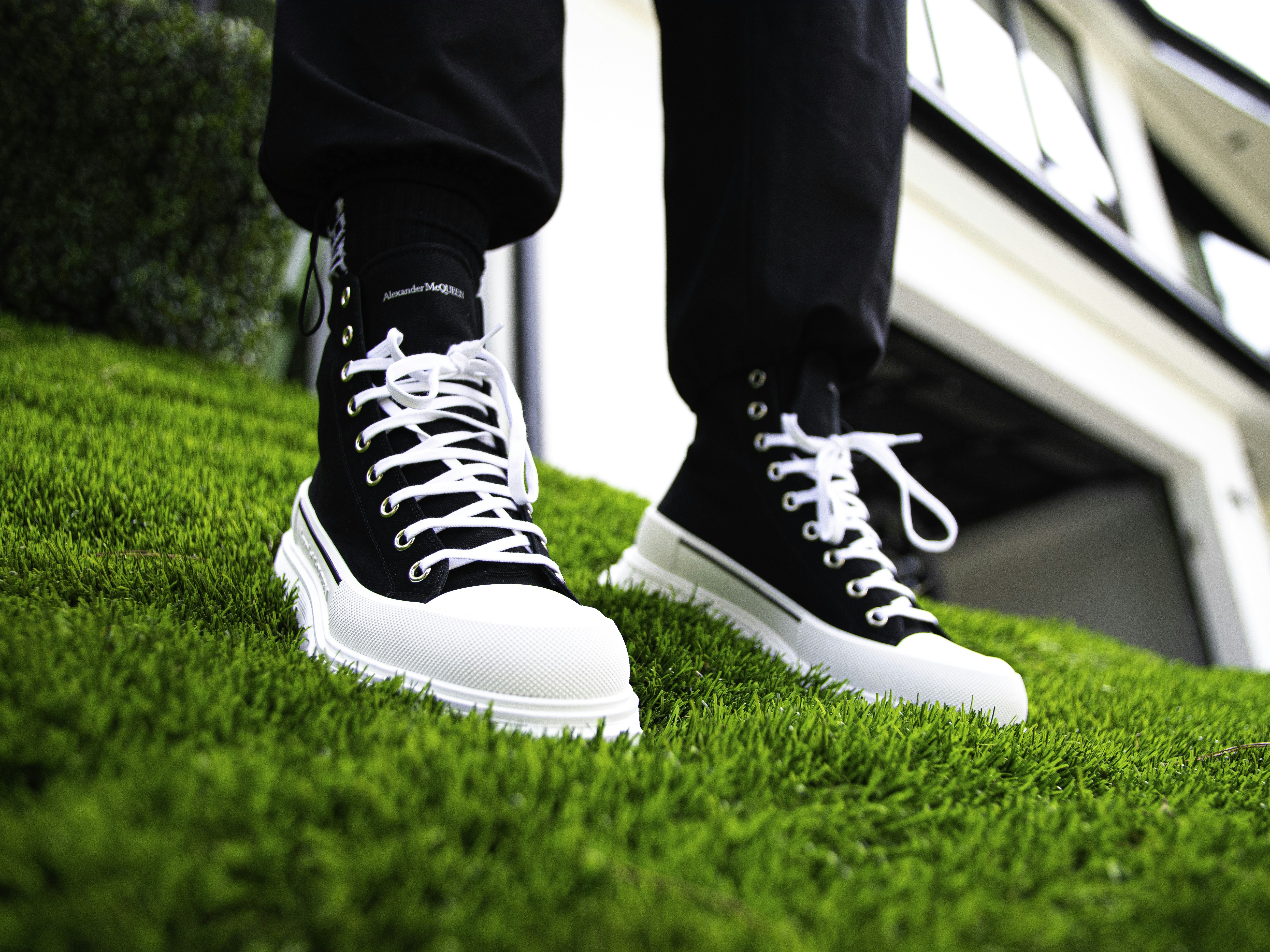 person in black pants and black and white nike sneakers