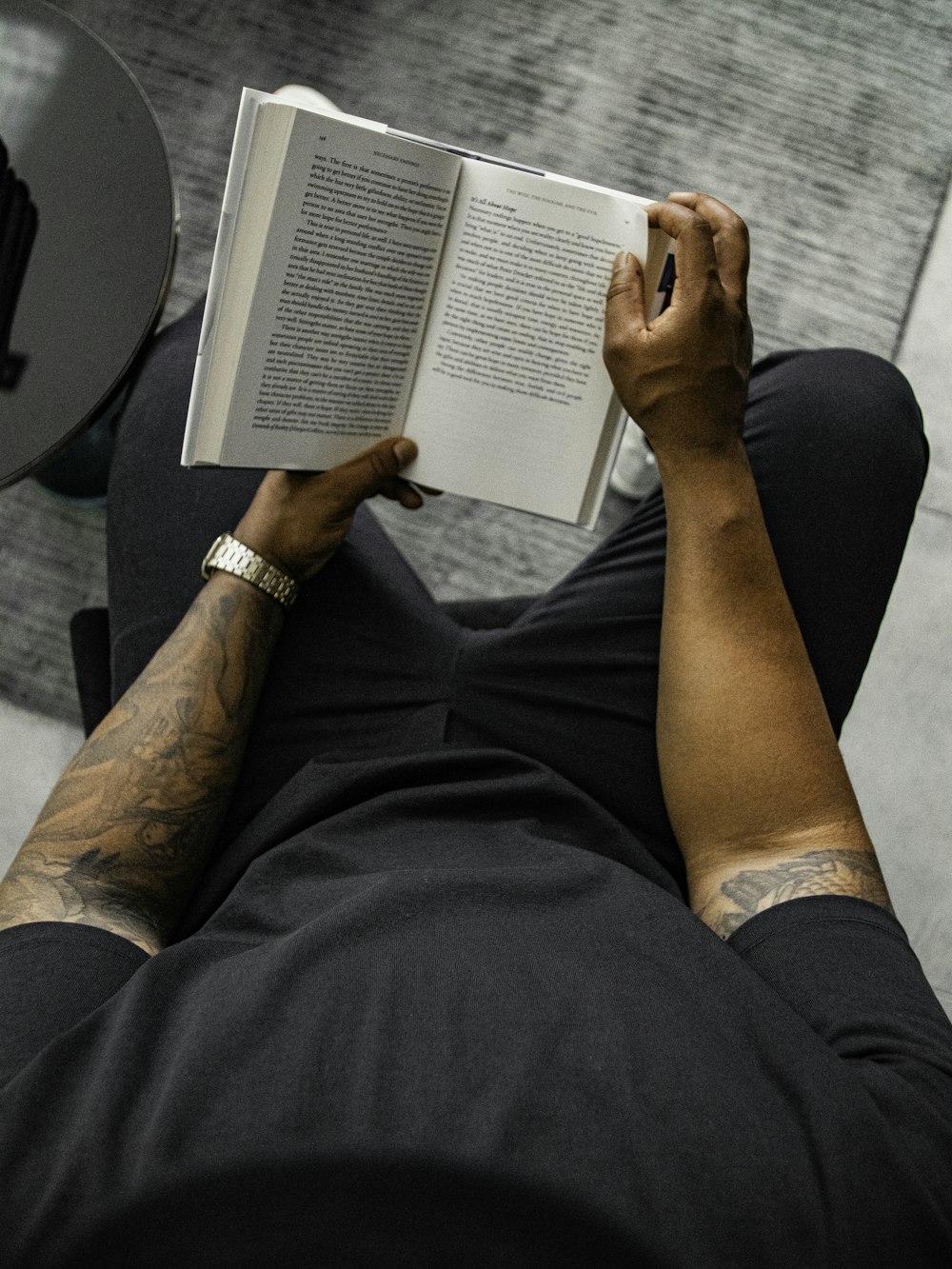 person in black pants reading book