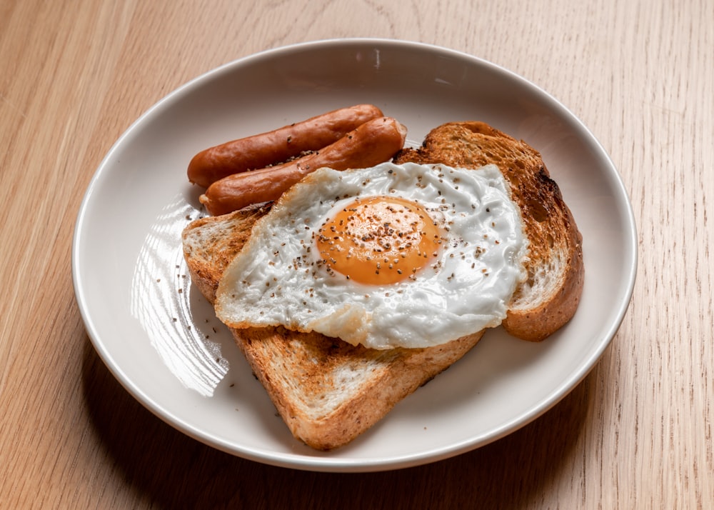 bread with sunny side up egg on white ceramic plate