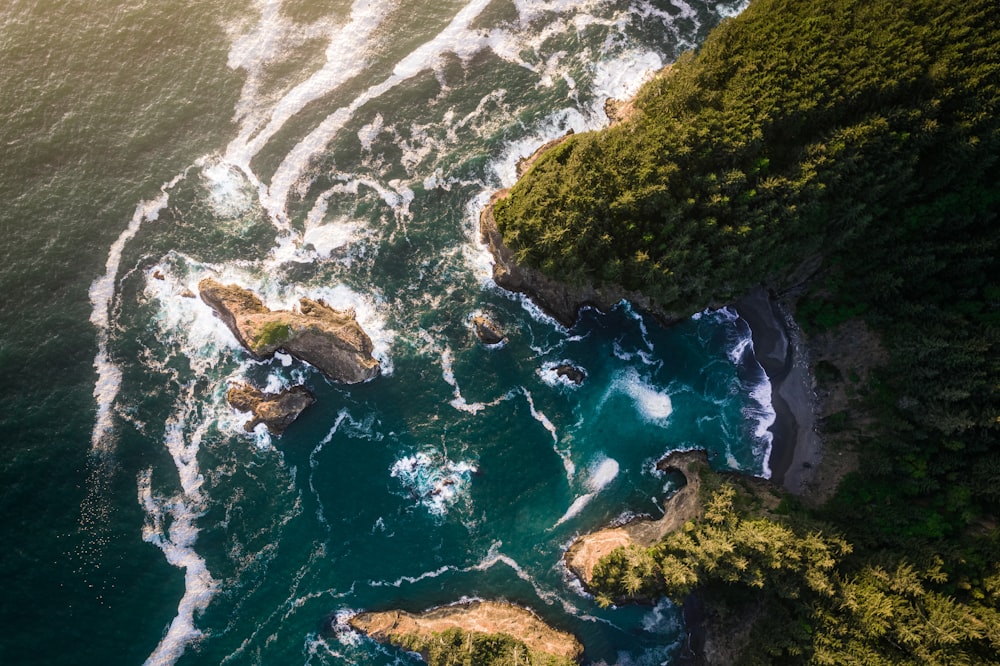 aerial view of green and brown rocky mountain beside body of water during daytime