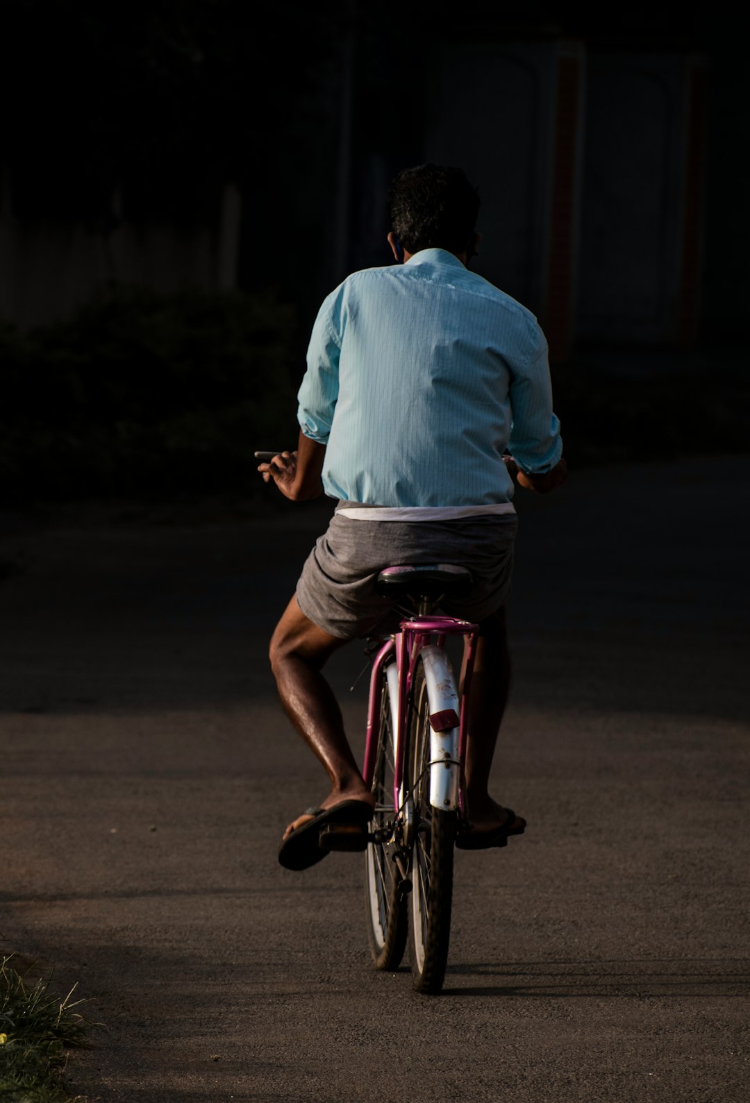 man in blue dress shirt riding on red and white bicycle during daytime