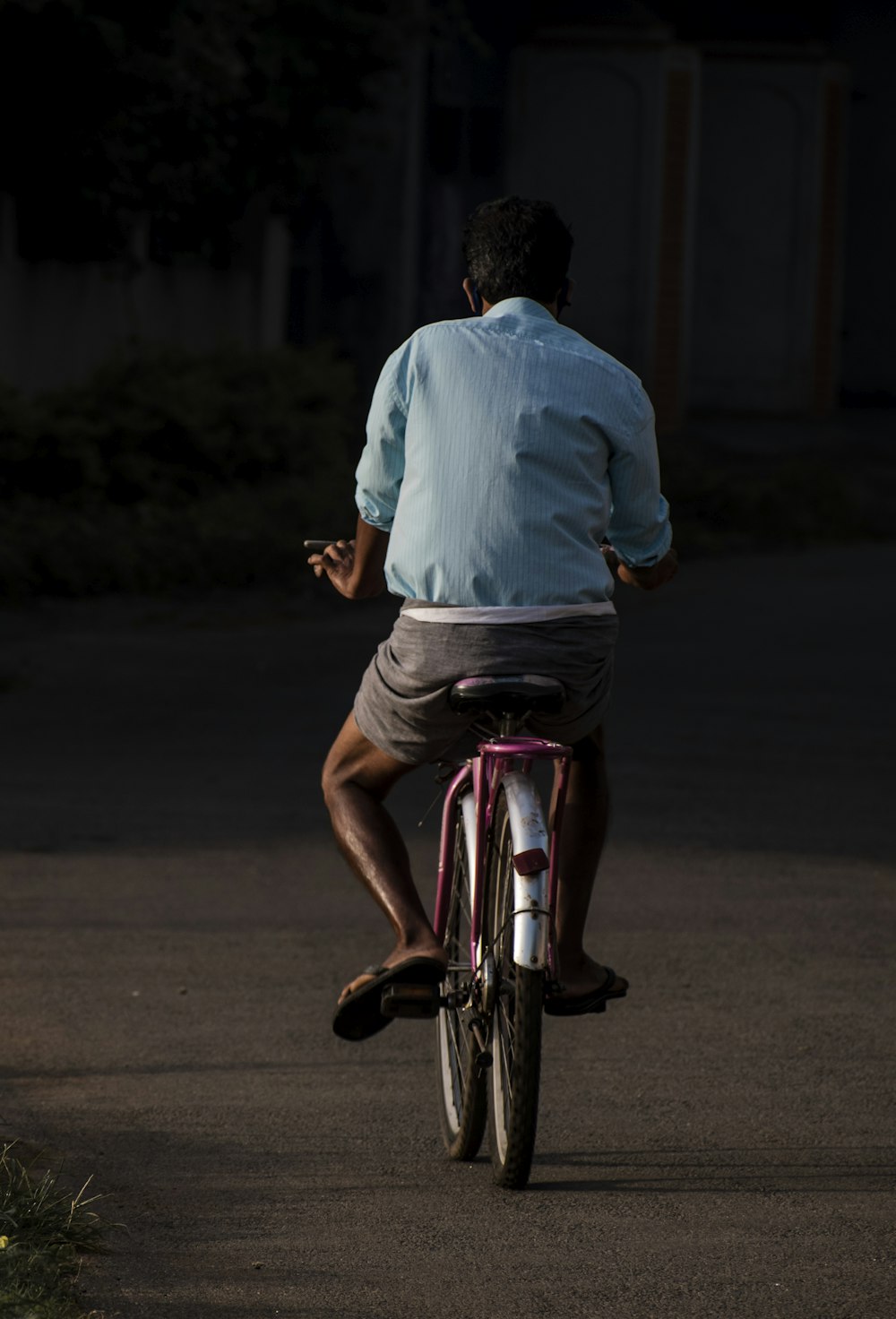 man in blue dress shirt riding on red and white bicycle during daytime