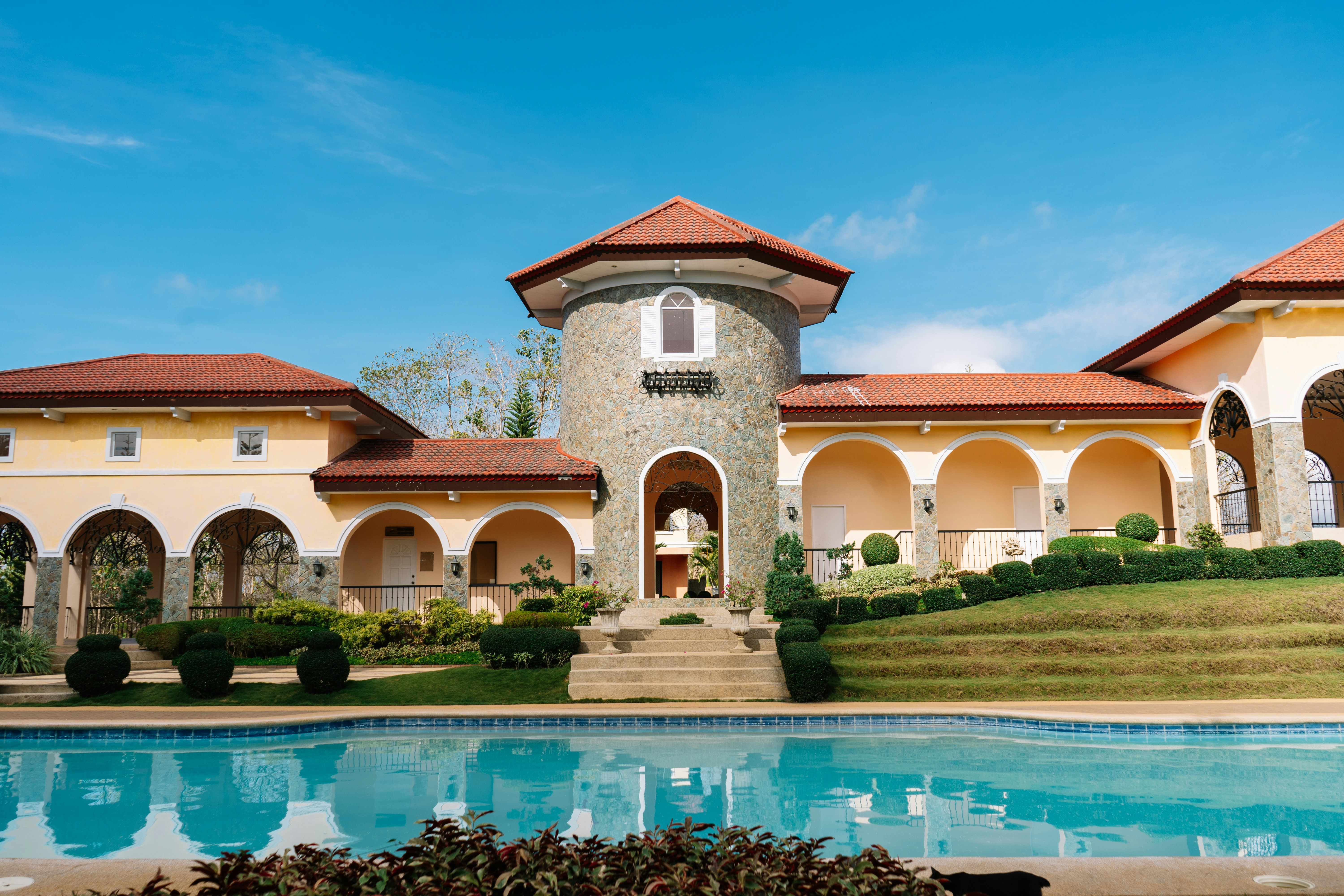 An aesthetic blue pool with a clubhouse and garden. A feature from Camella, a house and lot developer in the Philippines.