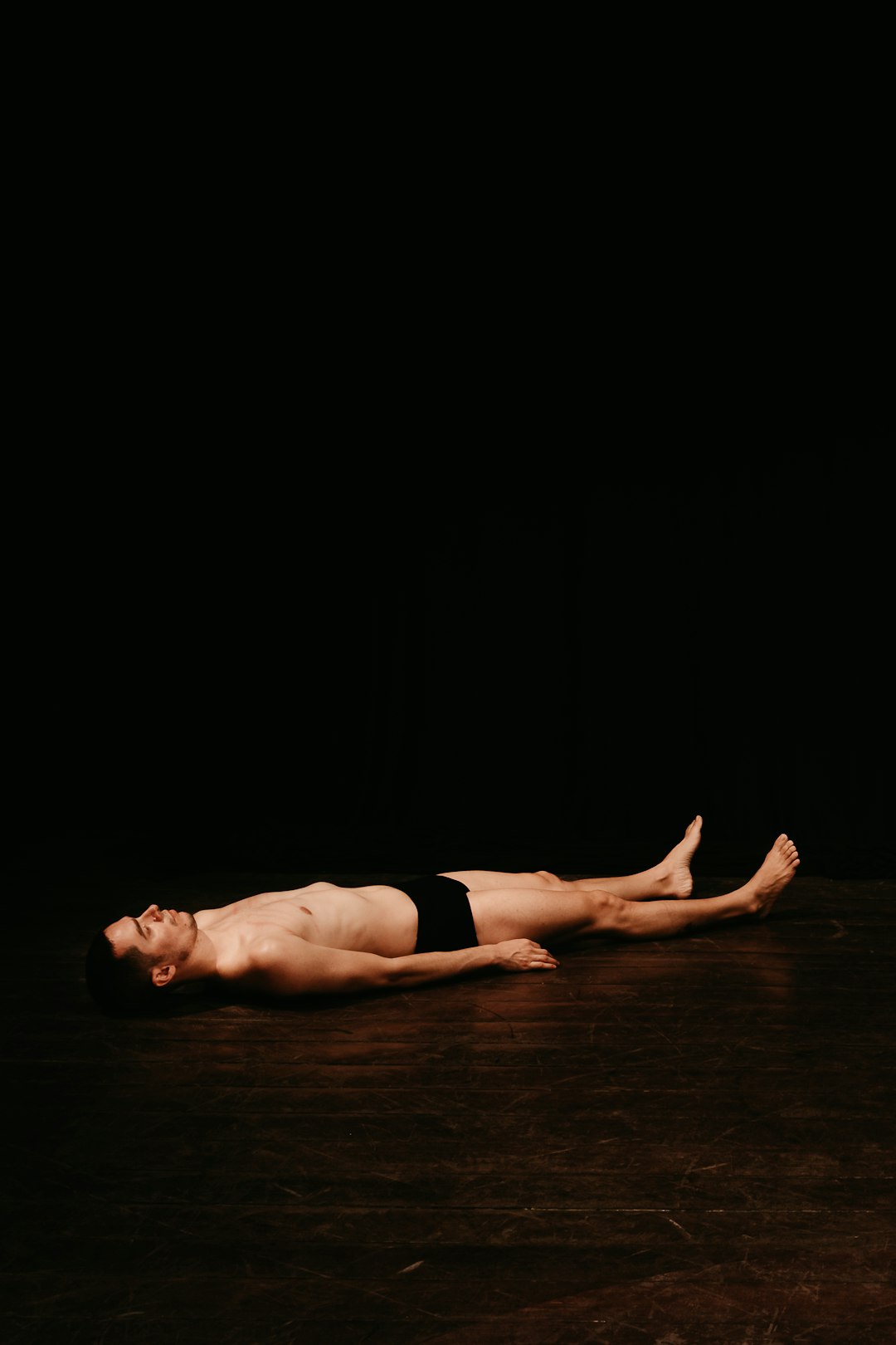 woman in black panty lying on floor