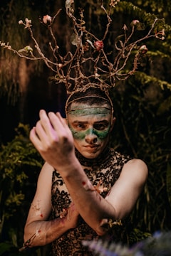 woman in black and white floral sleeveless top with green face paint