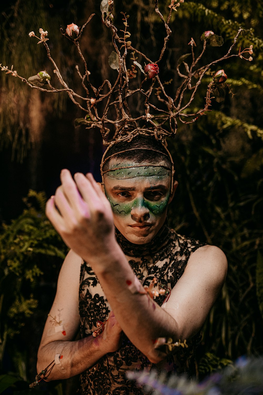 woman in black and white floral sleeveless top with green face paint