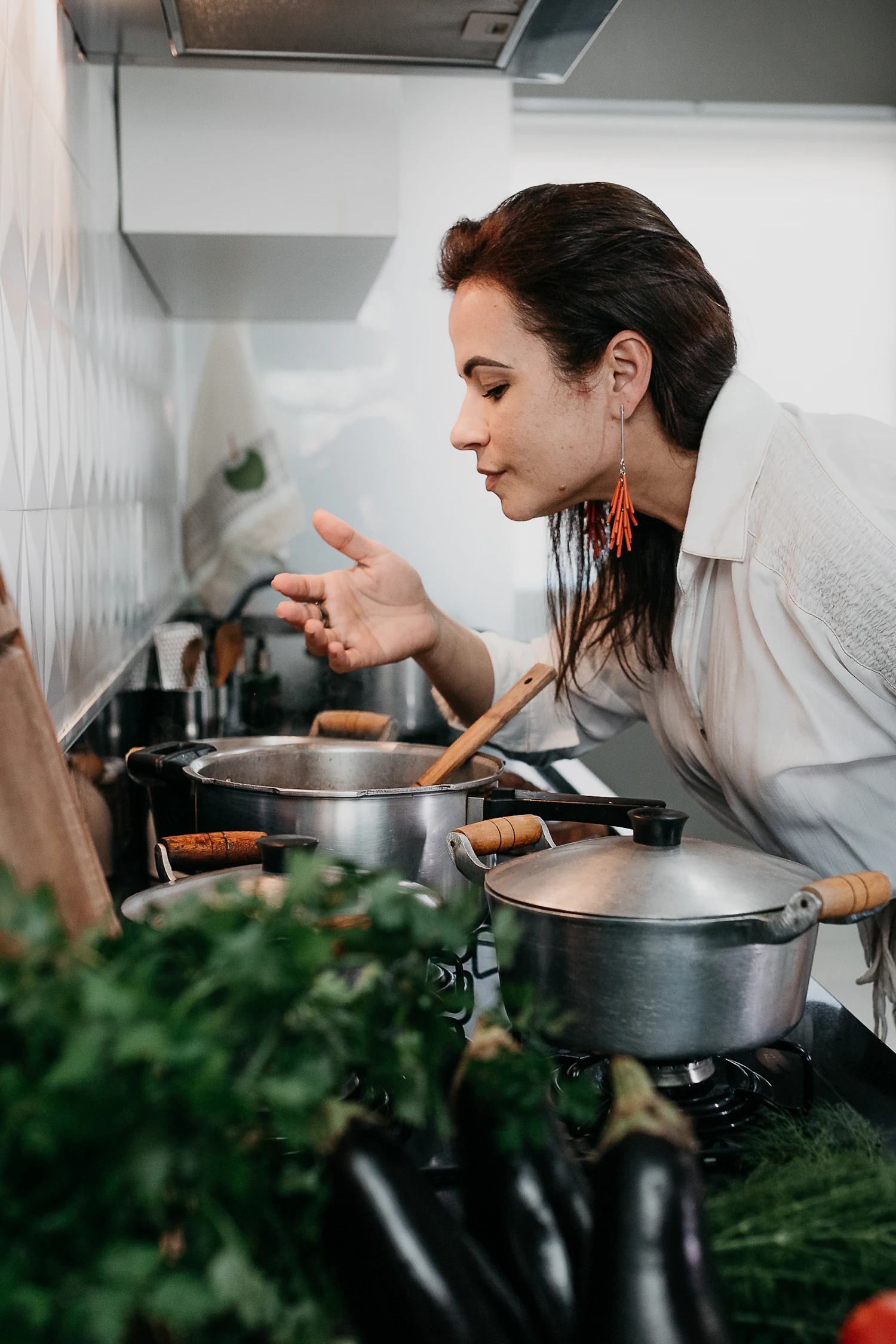 A woman working at a stove with two pans