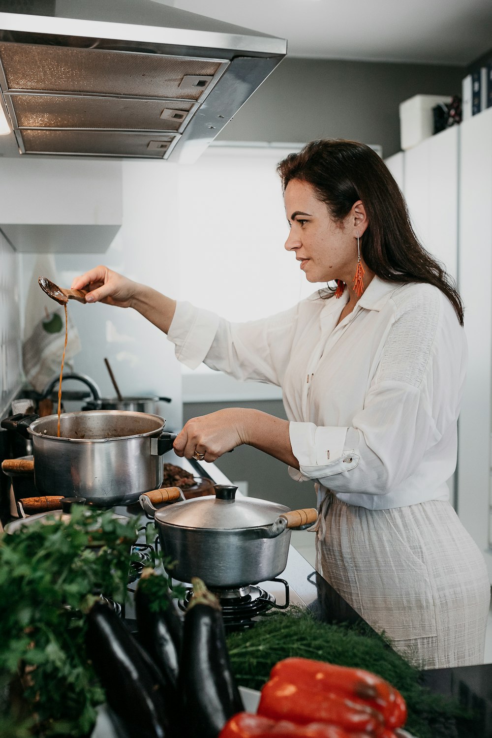 woman in white dress shirt holding stainless steel cooking pot