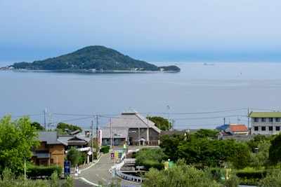 houses near body of water during daytime smoggy teams background