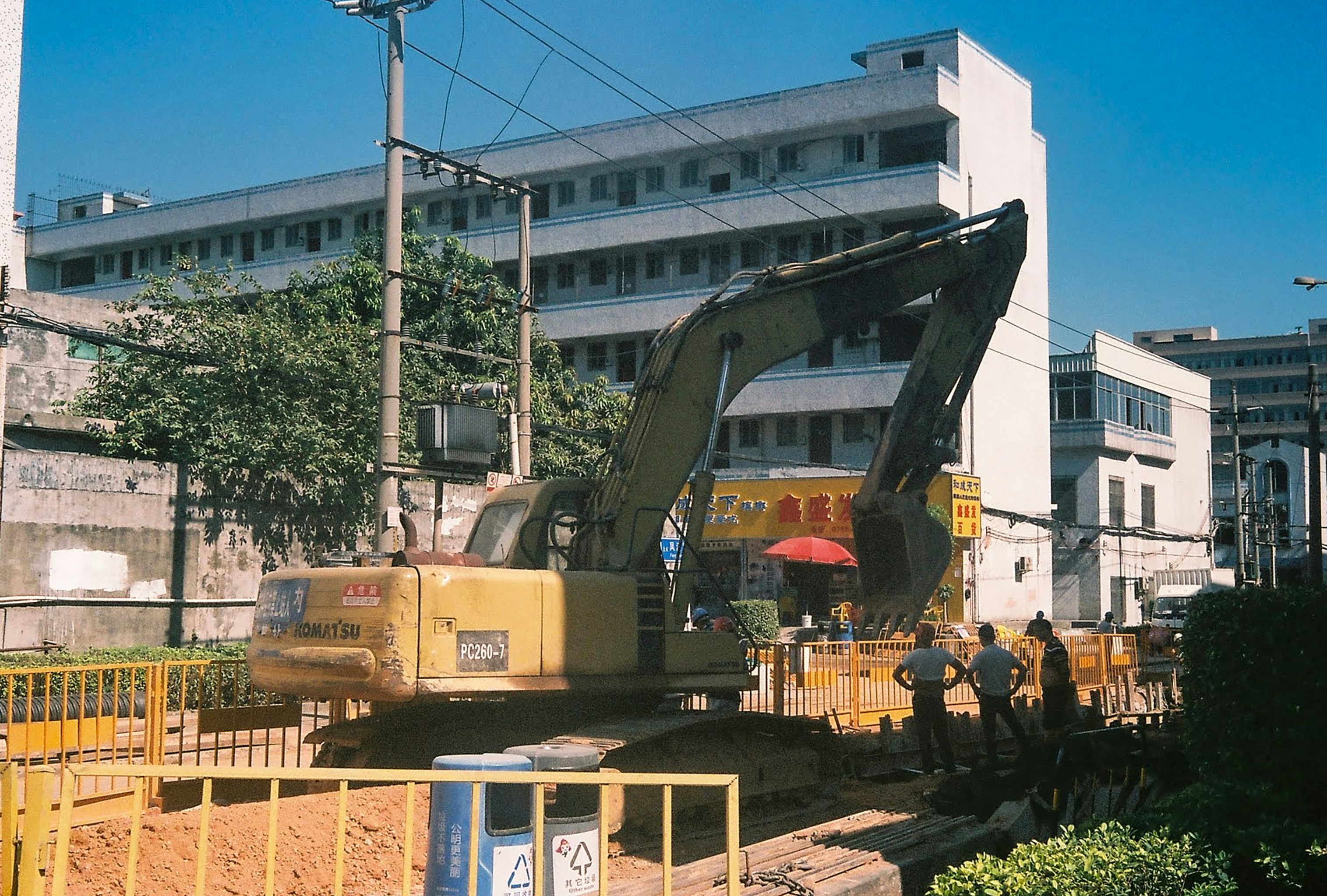 people standing near yellow heavy equipment during daytime
