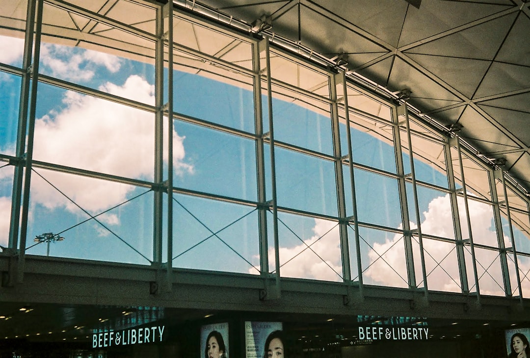 blue and white glass walled building under blue and white cloudy sky during daytime